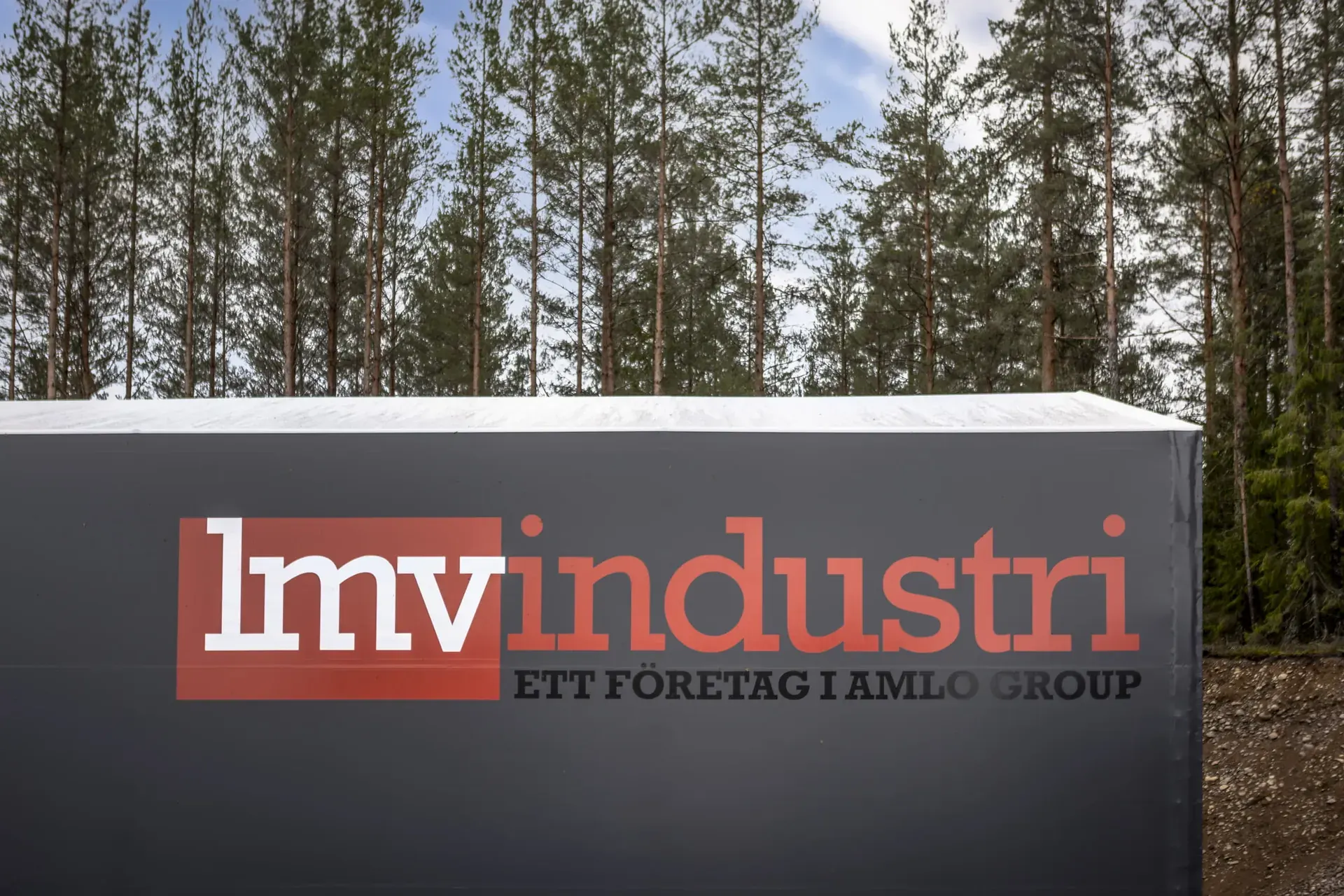 Skylt med lmvindustris logotyp framför fabriken i Lönneberga