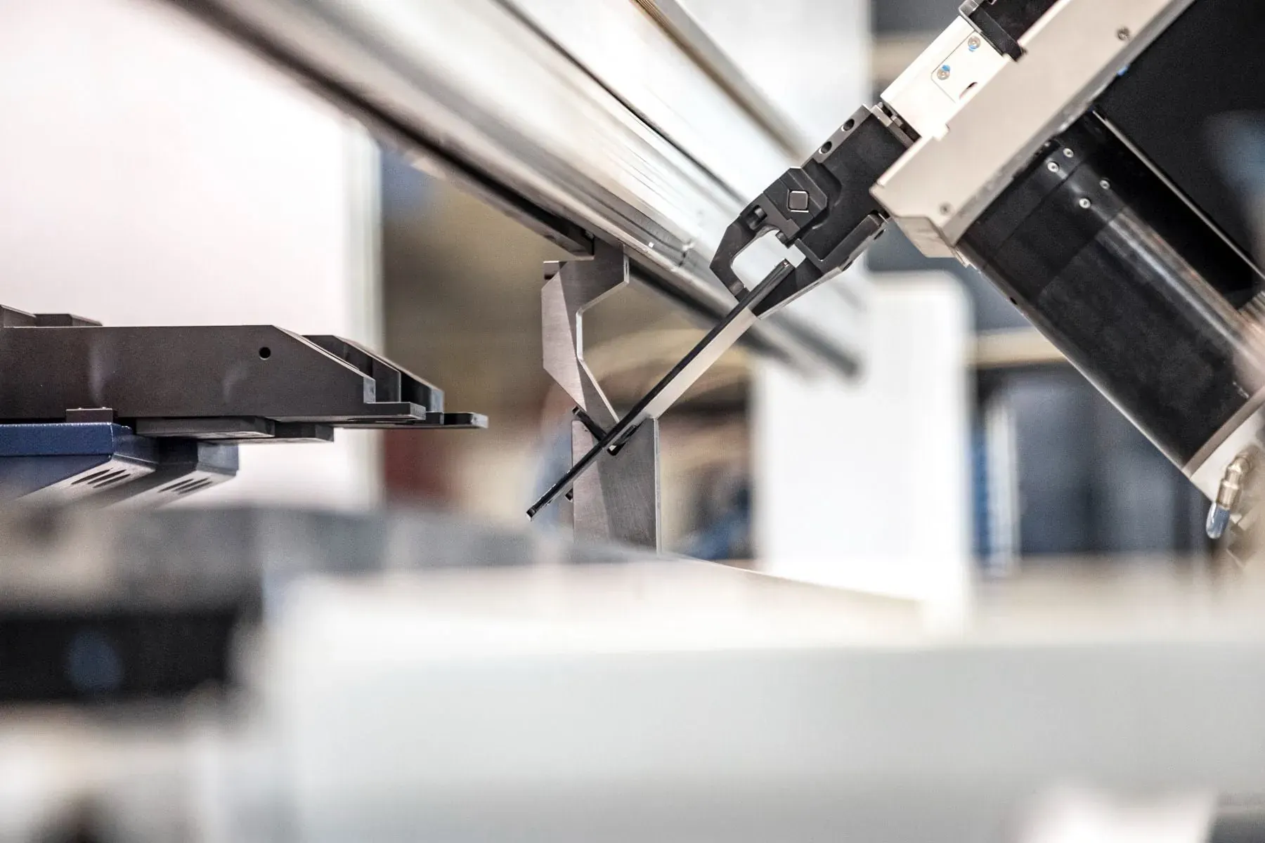 Robot som matar en plåtdetalj i en automatiserad kantpress